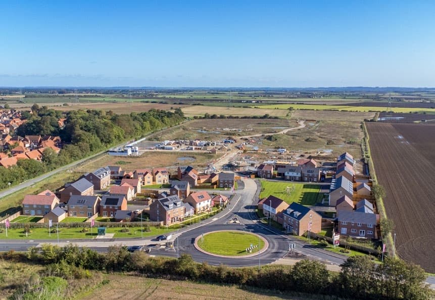 Aerial view of a completed Allison Homes development with a new roundabout, access road and surrounding countryside
